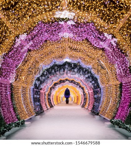 Christmas in  Moscow Russia. The light tunnel at Tverskoy Boulevard Tverskaya Street. New Year decorations beautiful magical lights. Silhouette of a woman in the end of the tunnel 