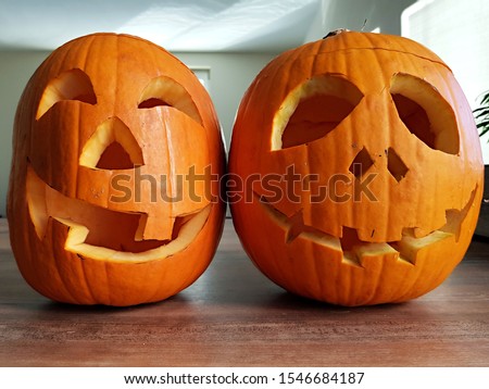 funny carved halloween pumpkins on wooden table