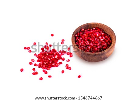 Pink pomegranate seeds in a wooden plate, on a white background natural light, fresh pomegranate fruit for diet, vegetarian food, skin care beauty, vitamin C, copy space