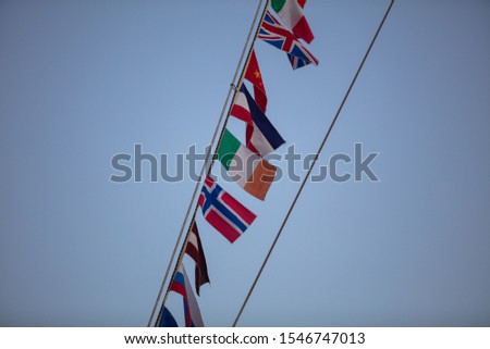flags of different nationalities fluttering on the mast of the ship