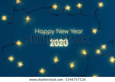 HAPPY NEW YEAR 2020 neon text in electric garland frame on blue background.