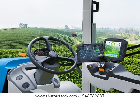 Autonomous tractor working in green tea field, Future technology with smart agriculture farming concept Royalty-Free Stock Photo #1546762637