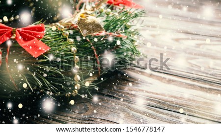 New Year and Christmas concept. A fragment of a Christmas wreath with a red bow and falling fluffy snow. Copy space for text