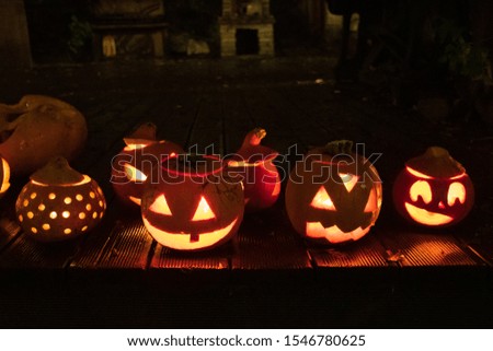 Spooky Halloween pumpkins, Jack O Lantern with burning candles on the wet wooden floor
