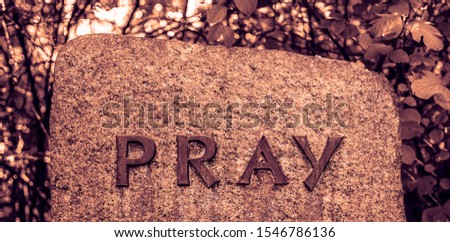The word - pray  made from vintage lead letterpress type on granite stone  background.