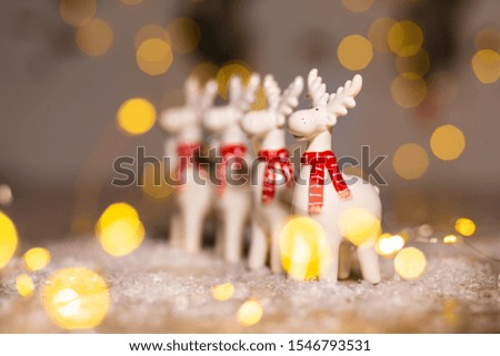 Decorative Christmas-themed figurines. Christmas deer. Christmas tree decoration. Festive decor, warm bokeh lights