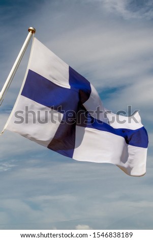 the flag of the Republic of Finland in the form of a blue cross on a white cloth, the pattern of Finland proudly evolving in the wind. blue cross on white background