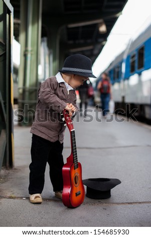 Boy with a guitar on a railway station