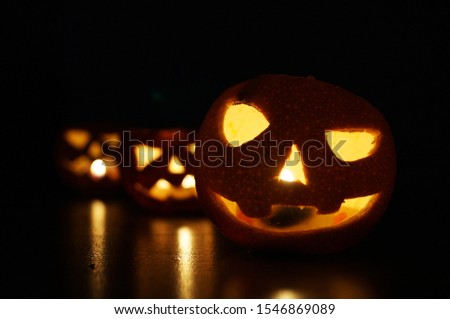 Halloween background night photo. Glowing Jack Lantern made of orange.
