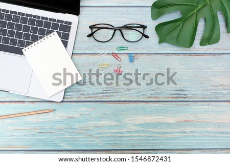 Flat lay, Business office concept on vintage wooden table desk with blank notepad and laptop computer, supplies, Top view with copy space, work space