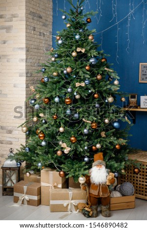 Modern design Christmas tree decorated with balls and garlands - navy blue, brown, beige. Winter holidays composition.