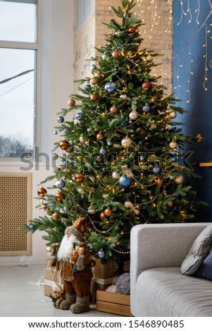Modern design Christmas tree decorated with balls and garlands - navy blue, brown, beige. Winter holidays composition.