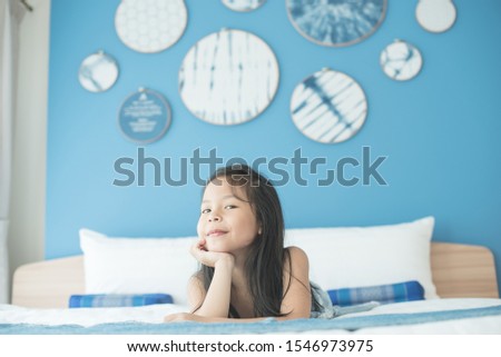 adorable little child girl sleeping in the bed. a nice child girl enjoys sunny morning. good morning at home. child girl wakes up from sleep. health and beauty concept