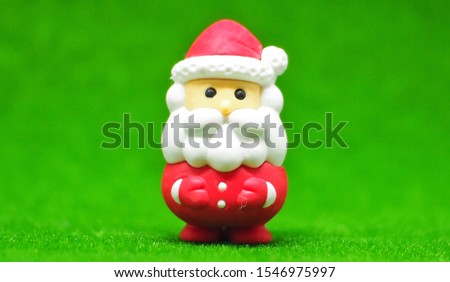 Close up Santa claus decoration on the green blurred texture background. 