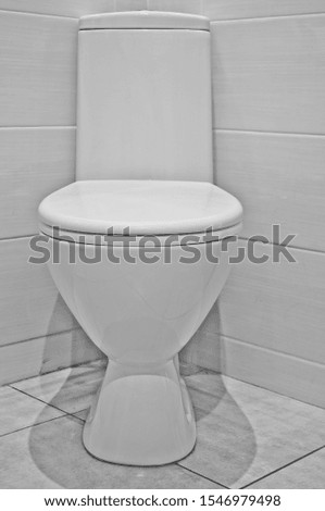 stock photo white toilet on a ceramic tile in the corner of the room on a light background