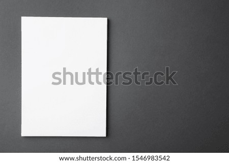 Blank paper sheets on dark grey background, top view. Mock up for design