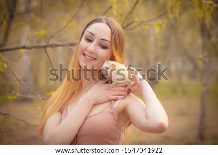 Beautiful girl with a hedgehog on his shoulder. The woman is smiling. Decorative rodents.