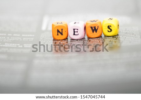 Word news. Wooden cubes on newspaper. News information concept.