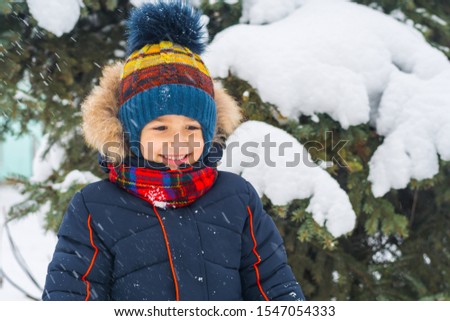 smiling boy on the background of snow-covered spruce