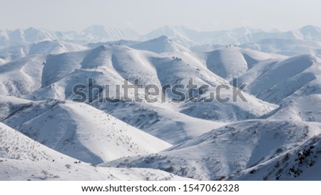 Aerial view of snow-capped mountains. Traveling and hiking in the far north of Russia. Location place: Meingypilgyn Range, Chukotka, Siberia, Russian Far East.