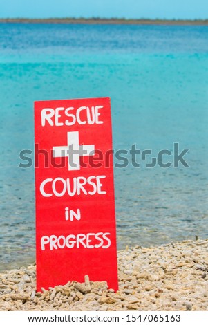 Red warning sign for rescue exercise on beach by the sea