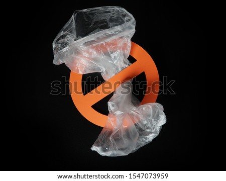 Empty plastic bag in a stop sign on black background. Concept of stop plastic pollution, global warming, recycling plastic, plastic free.