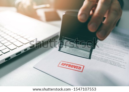 approved stamp - businessman stamping document in office Royalty-Free Stock Photo #1547107553