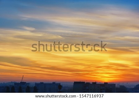 Clouds at sunrise over morning city.