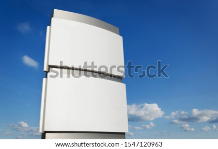 Blank company sign board mockup  outdoors against blue sky 