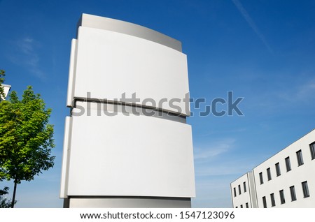 Blank company sign board mockup outdoors with company building against blue sky