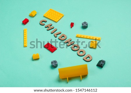 Childhood concept. Toy bricks on blue paper background. Top view