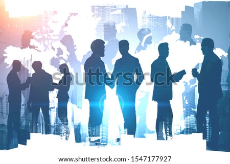 Diverse business people working together over cityscape background with double exposure of world map. International partnership concept. Toned image. Elements of this image furnished by NASA