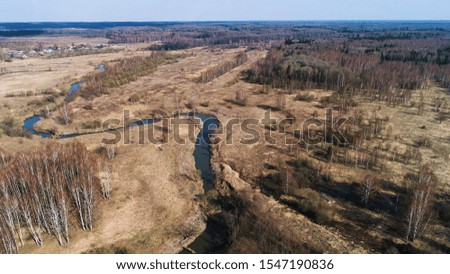 River bend in the shape of a horseshoe. Aerial view. Early spring, landscape with dead grass.