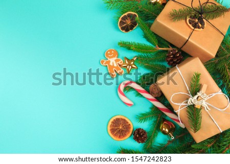 Christmas border. Christmas gifts, fir branches on color background. Flat lay, top view, copy space