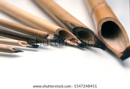Traditional calligraphy pencils isolated in white background. Ottoman, Arabic, Persian and orient culture. Calligraphy, arts, lettering, bamboo concepts. Horizontal macro shot.