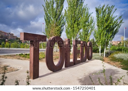 Welcome to Toledo, Spain. Welcome sign at the entrance of the city of Toledo with large letters on the ground and brown. In the background old city on a sunny day with clouds.