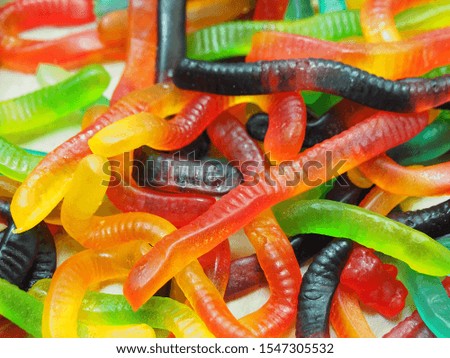 Background сhewy colorful jelly marmalade in the shape of a worm. Sweet edible fun for kids closeup