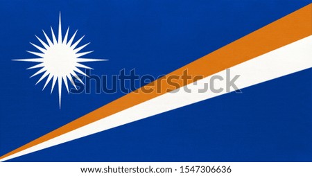 Republic of the Marshall Islands national fabric flag, textile background. Symbol of international world oceania country. State official sign.