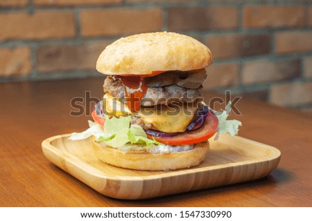 Double burger with cucumbers and tomato
