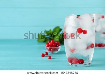 Glass of cocktail with vodka, ice and cranberry on blue wooden table. Space for text