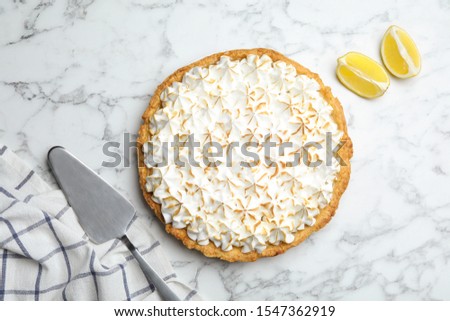 Flat lay composition with delicious lemon meringue pie on white marble table