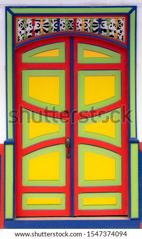 Wooden door, decorated with panels with lines and curves, in vibrant colors in Filandia, Quindío, Colombia
