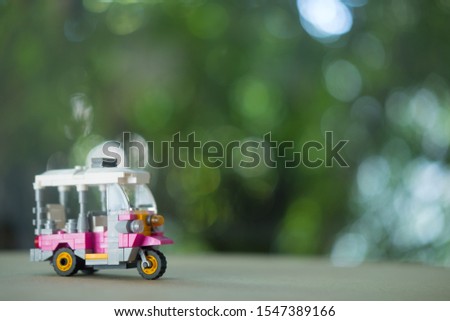 Toy miniature tuk-tuk or tricycle in Thailand with nature background. Travel in Thailand