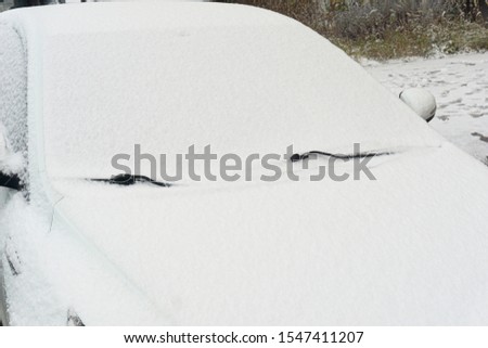 Snow-covered car windshield. parked car covered with snow during snowing in winter time.