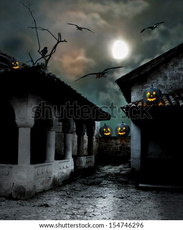 Halloween pumpkins in the yard of an old house at night in the bright moonlight