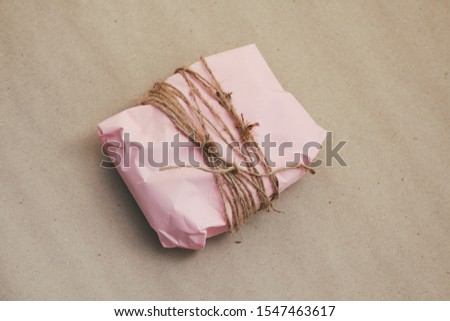 Soft pouch wrapped in craft paper and tie cord. Crumpled paper background texture. Delivery service. Online shopping.	