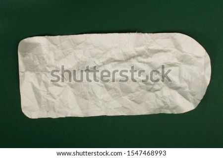 White piece paper on dark green background