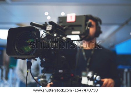 Professional cameraman with headphones with HD camcorder in live television Royalty-Free Stock Photo #1547470730