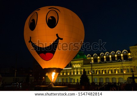 Hot air balloon with yellow smiley face at night festival