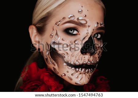 Portrait of a woman with sugar skull makeup over red background. Halloween costume and make-up.  Royalty-Free Stock Photo #1547494763